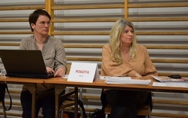 Sala gimnastyczna w Mszanie. Widok na stanowisko Urzędu Pracy. Dwie pracownice siedzą za stołem z dokumentami