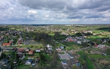 gmina-z-lotu-ptaka-15 - widok na centrum sołectwa Mszana. Z daleka Urząd Gminy i Park znajdujący się za nim. Powyżej niebo z chmurami